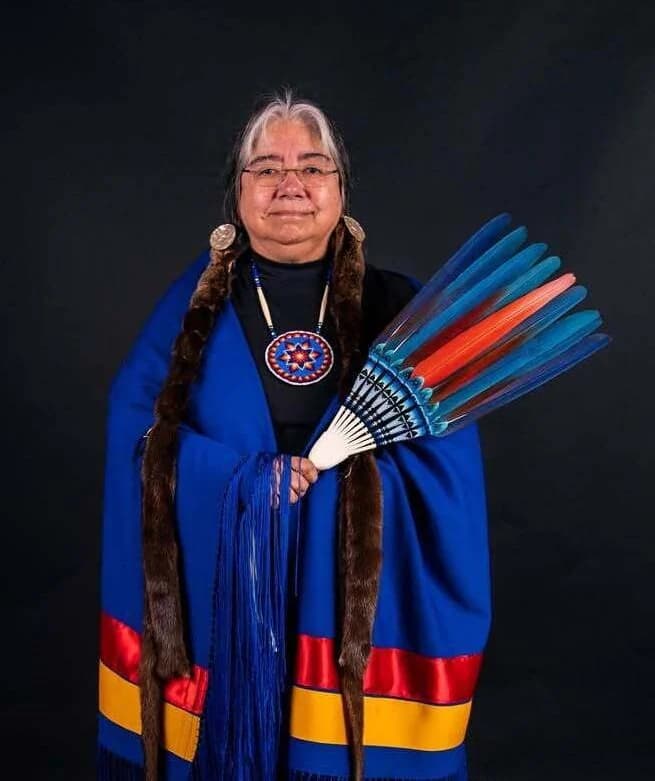 Portrait of Lita Shelton holding a blue and orange feather fan
