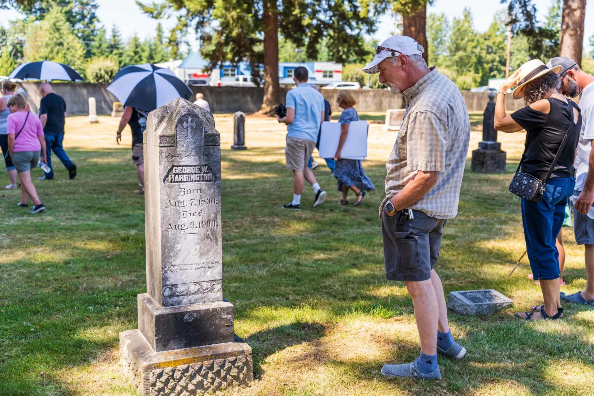 Tour visitors pause at George W. Harrington's gravestone during the 2025 event