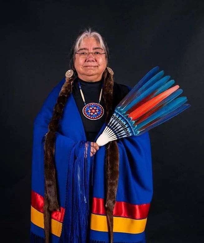 Portrait of Lita Shelton holding a blue and orange feather fan